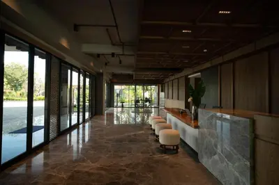a lobby with a bar with stools and windows at Lavaya Resort Nusa Dua Bali in Nusa Dua