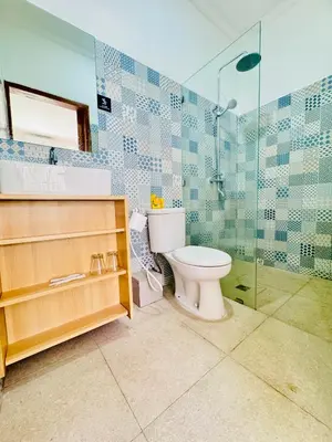 a bathroom with a toilet and a glass shower at Y&J in Seminyak