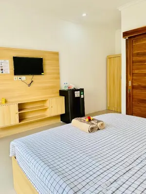 a bedroom with a bed and a flat screen tv at Y&J in Seminyak