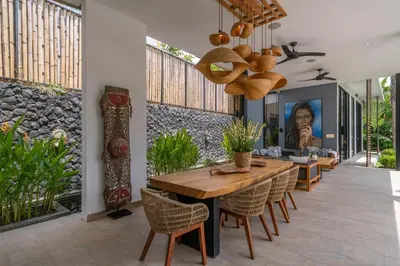 a dining room with a wooden table and chairs at Villa Vida Mira - Elegant 4BR Beachside Villa in Canggu in Canggu