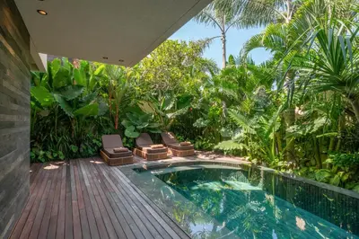 a house with a swimming pool in a garden at Villa Fiji by Villa Finder in Canggu