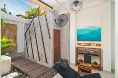 a living room with a balcony with a tv at 3BR Villa Kita - Minggu Villas-Special Stay Bonus in Seminyak