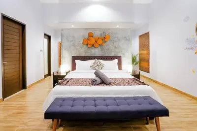 a large bedroom with a large bed with a blue bench at Villa Narada - Convenient Location - Private Pool - 3BR Villa in Seminyak