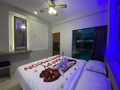 a bedroom with a bed with white sheets and flowers on it at Bali queen elephant boutique villa in Jimbaran