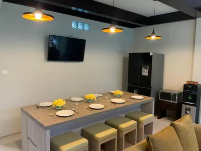 a dining room table with chairs and a television at Bali queen elephant boutique villa in Jimbaran