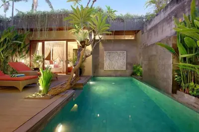 an infinity pool in a house with palm trees at Cozy 2 BR Private Pool Villa in Seminyak