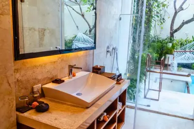 a bathroom with a sink and a glass shower at Smart 1 BR Villa with Private Pool in Seminyak