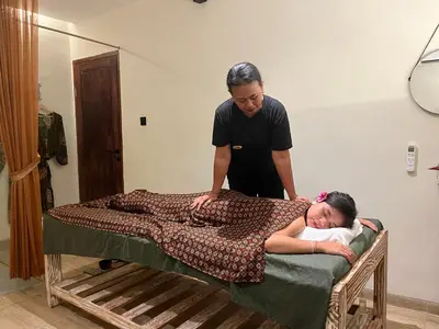 a man helping a woman laying on a bed at Abian Klumpu Villa & Spa Sanur Bali in Sanur