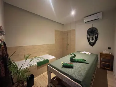 a bathroom with a green table and a bath tub at Abian Klumpu Villa & Spa Sanur Bali in Sanur