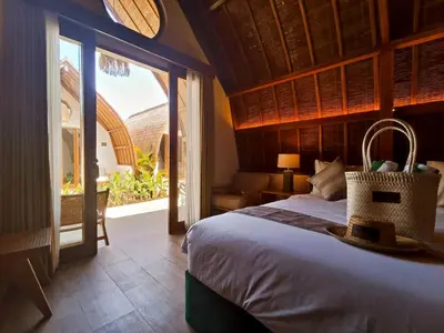 a bedroom with a bed and a large window at Abian Klumpu Villa & Spa Sanur Bali in Sanur