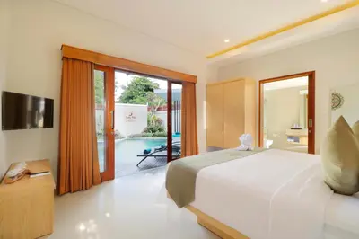 a bedroom with a bed and a sliding glass door at Sudha Villa Bali A in Seminyak