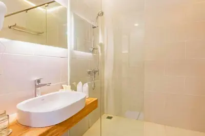 a white bathroom with a sink and a shower at Luxury 1 BR Deluxe Twin Room in Canggu