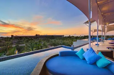 a pool with a blue couch and a sunset at Antariksha 1 BR Superior Room in Seminyak