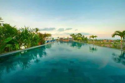 a large swimming pool at a resort with palm trees at Damarlangit 1 BR Superior Terrace in Seminyak