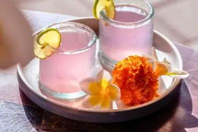 a plate with two glasses and flowers on a table at Luxury 2 BR Villa with Private Pool & Bathtub in Seminyak