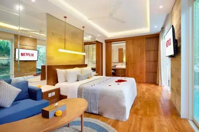 a bedroom with a large bed and a blue couch at Luxury 2 BR Villa with Private Pool & Bathtub in Seminyak