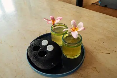 a black plate with two glasses and flowers on a table at Entire 1 BR Villa With Private Pool in Seminyak