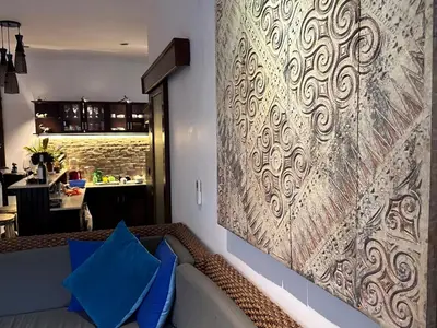 a wall mural in a living room with blue pillows at Villa Petra Seminyak Bali in Seminyak