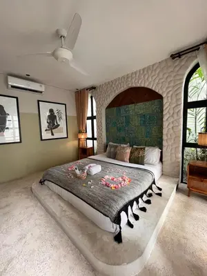 a bedroom with a large bed with a stone wall at Casa Toledo 1 Bedroom Seminyak - Kerobokan in Seminyak