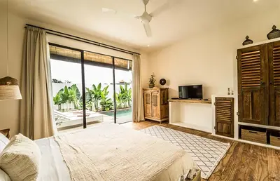 a bedroom with a large bed and a large window at Villa Kosibali by Optimum Bali Villas in Kerobokan