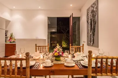 a dining room with a wooden table and chairs at Gajah Villas Bali by Nagisa Bali in Seminyak