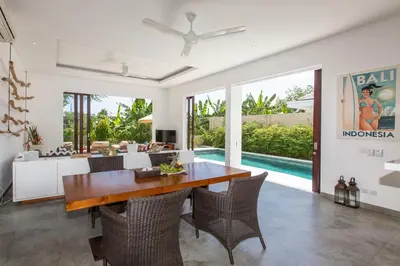a dining room with a table and chairs at Gajah Villas Bali by Nagisa Bali in Seminyak