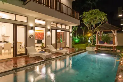 a villa with a swimming pool at night at Villa Club Corner Residence by Nagisa Bali in Canggu