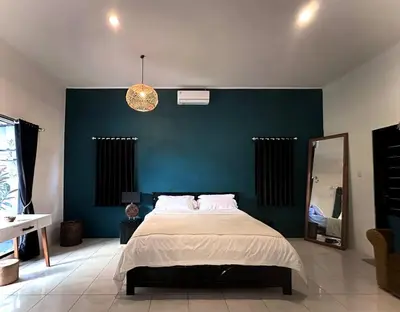 a bedroom with a large bed and a blue wall at 2 BR Villa Rhapsody - 5 Mins to Seminyak/Umalas in Seminyak
