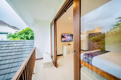 a bedroom with a bed and a balcony at Villa Julissa in Seminyak