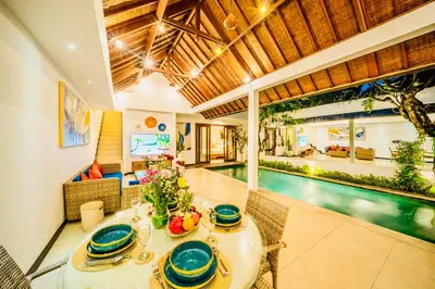 a dining room with a table and a pool at Villa Julissa in Seminyak