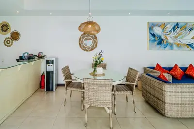 a dining room with a table and chairs and a couch at Villa Julissa in Seminyak