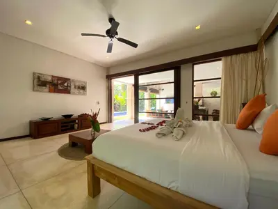 a bedroom with a large white bed with a ceiling fan at Spacious Villa in Petitenget Top Location in Seminyak