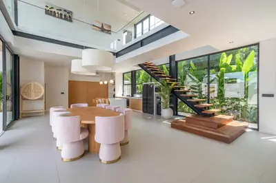 a dining room with a table and chairs and a staircase at Villa Maverick - Brand New Classy 4BR Villa in Canggu in Canggu
