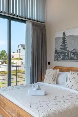 a bedroom with a large bed with a large window at Villa Maverick - Brand New Classy 4BR Villa in Canggu in Canggu