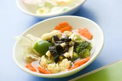 a bowl of food with vegetables on a table at Amaris Hotel Teuku Umar in Denpasar