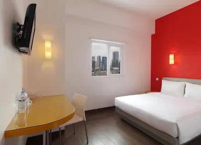 a hotel room with a bed and a table and a desk at Amaris Hotel Teuku Umar in Denpasar