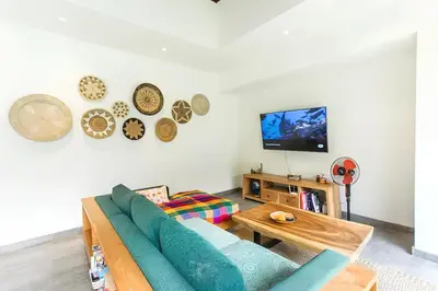 a living room with a blue couch and a tv at Villa GrandLux Bali 2 Bed Villa Pool Big Garden in Seminyak