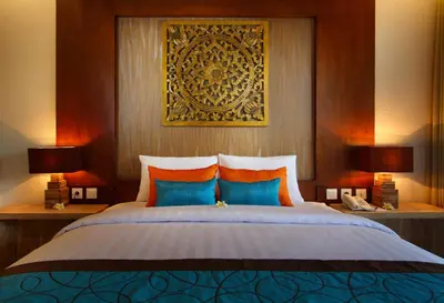 a bedroom with a bed with two lamps and a picture on the wall at Destiny Boutique Hotel in Seminyak