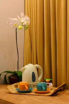 a table with a tea set and a tea pot and flowers at Destiny Boutique Hotel in Seminyak