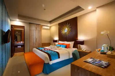 a hotel room with a bed and a desk with at Destiny Boutique Hotel in Seminyak