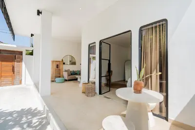 a living room with white walls and a table at Villa Arawan - Beautiful 3BR Villa in Kerobokan in Kerobokan