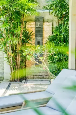 a view of a garden with a window and plants at Virginia villa 4BR 5min walk to beach with assistant villa and pick up from airport and security in Canggu