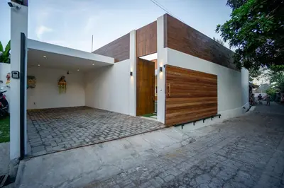 a house with a wooden door on the side of it at Villa Marlex by Bukit Vista in Seminyak