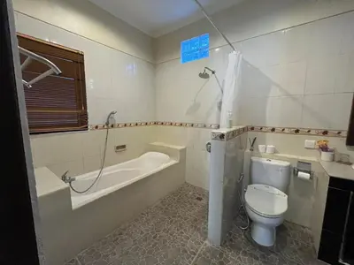 a bathroom with a tub and a toilet and a sink at Kubu D Kubu Villa - 3 Bedroom - Legian in Legian