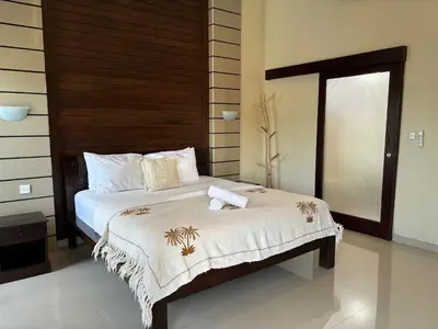 a bedroom with a bed with towels on it at Kubu D Kubu Villa - 3 Bedroom - Legian in Legian