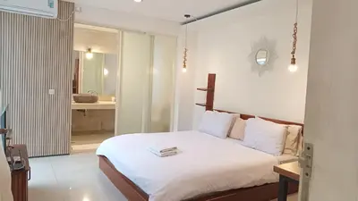 a bedroom with a white bed and a bathroom at 3 BR Chrysanthemum Villa nusadua in Nusa Dua