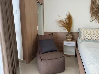 a bedroom with a chair next to a bed at HomelyBali, Cozy studio in Rajapala! in Seminyak