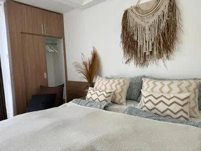 a bedroom with a bed with pillows on it at HomelyBali, Cozy studio in Rajapala! in Seminyak