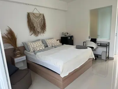 a bedroom with a large bed and a chair at HomelyBali, Cozy studio in Rajapala! in Seminyak