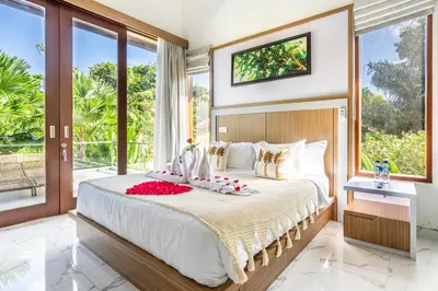 a bedroom with a large bed with flowers on it at Villa Sun Lila by JB Villas in Seminyak